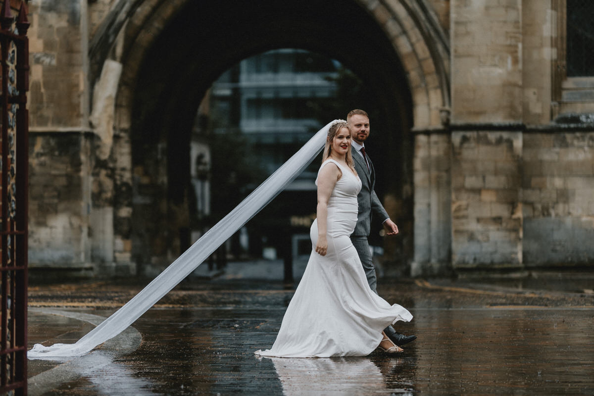Happy newly wed couple outside Oxford Bodleian Library. Alternative confetti shot.