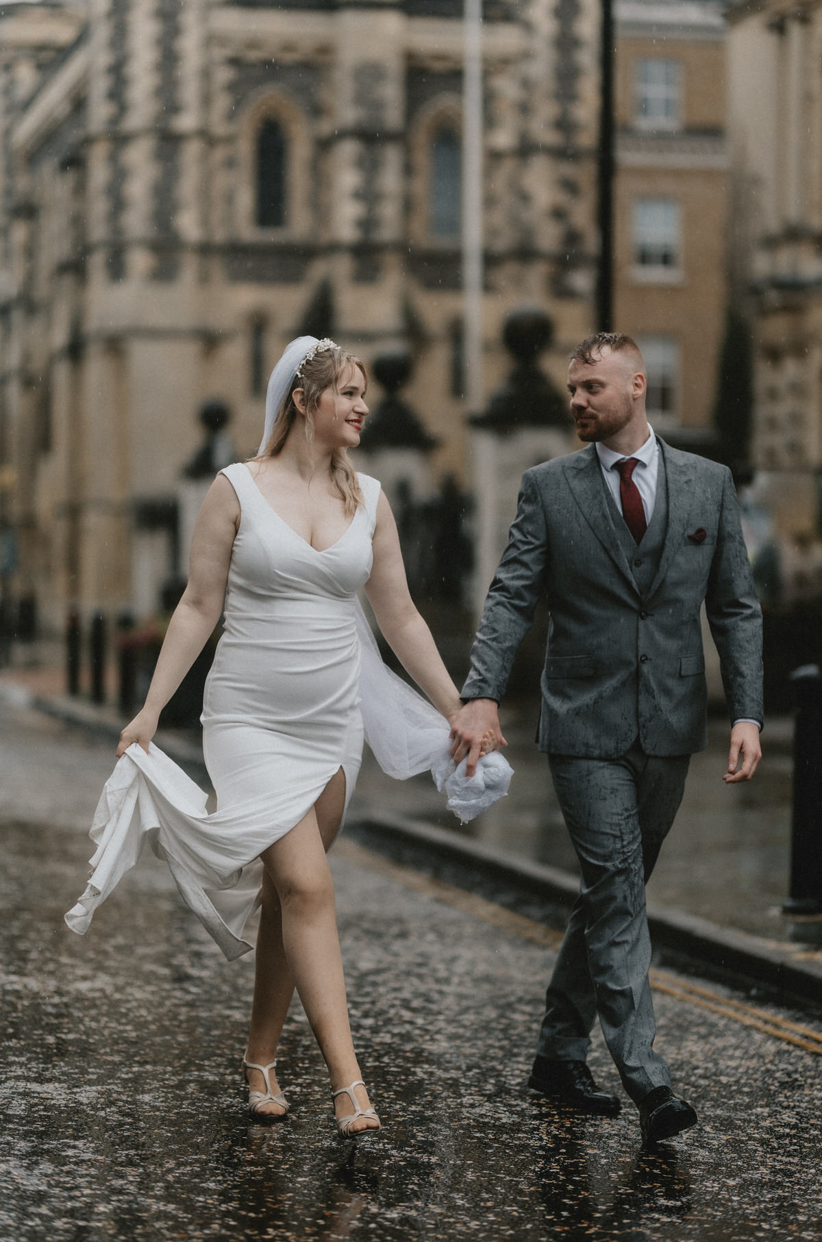 Happy newly wed couple outside Oxford Bodleian Library. Alternative confetti shot.