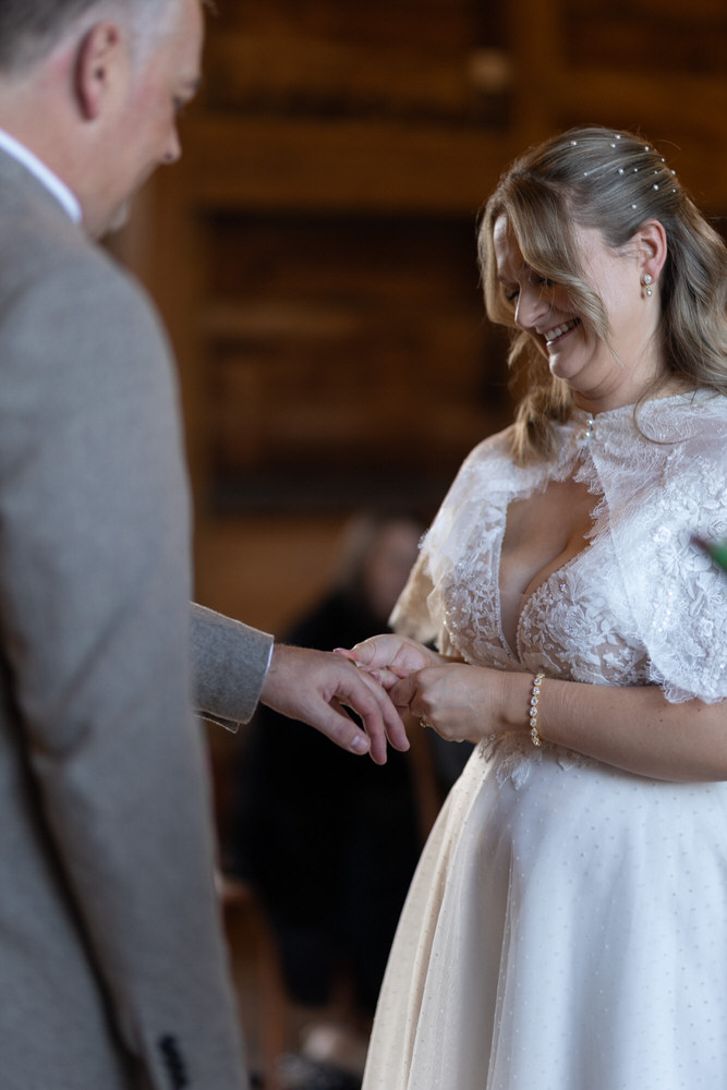 Bride in a white dress holding a glass of champagne smiling
